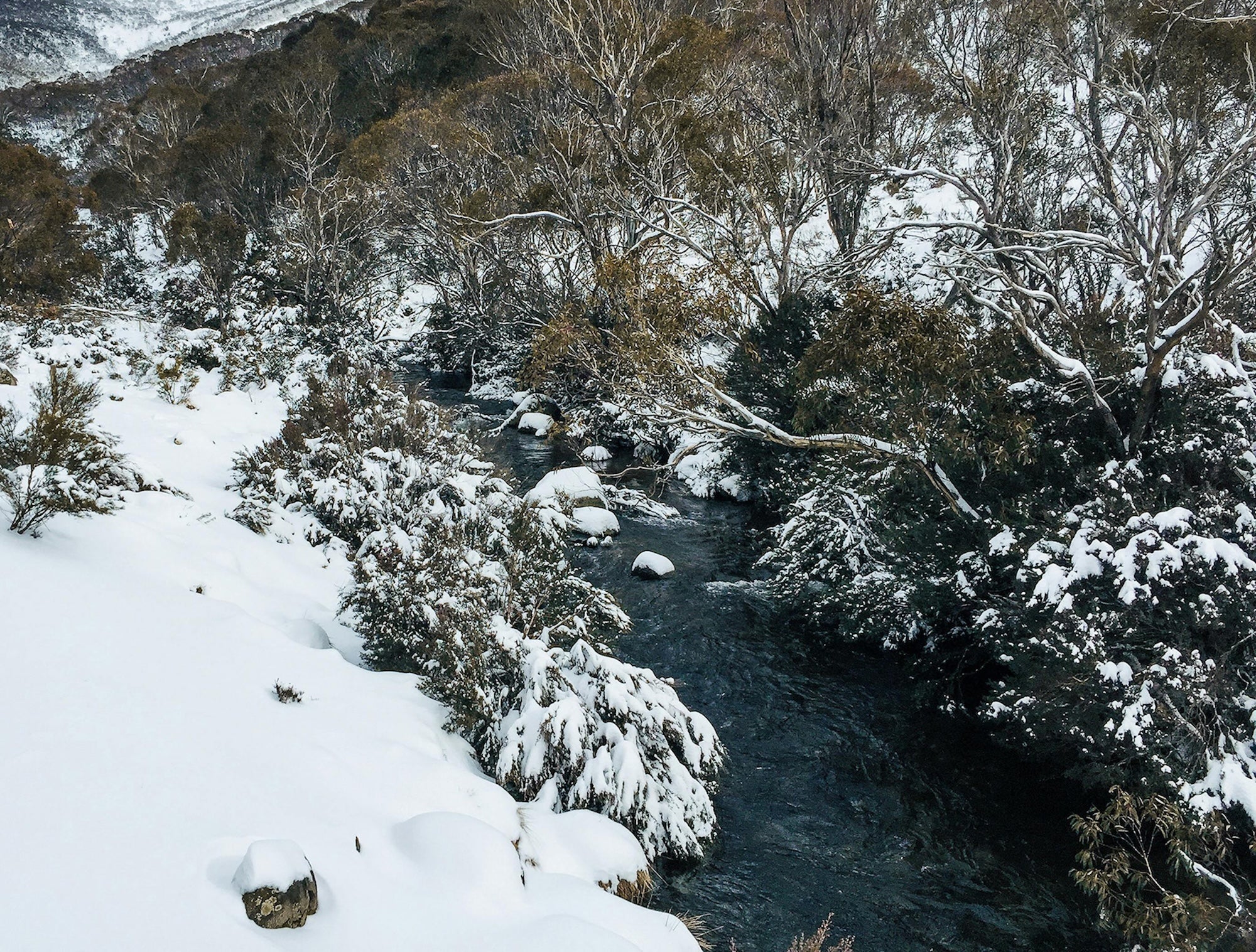 a natural river cutting through  snowy landscape