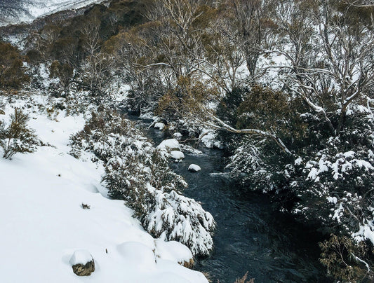 a natural river cutting through  snowy landscape